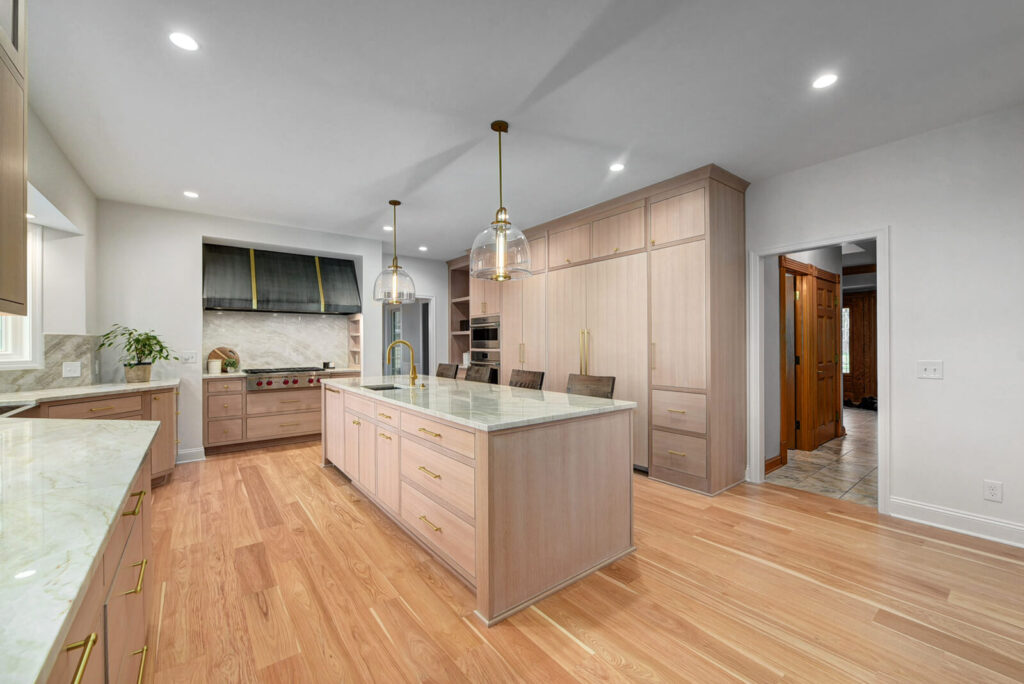 A modern kitchen featuring a central island and elegant wooden flooring, creating a warm and inviting atmosphere.