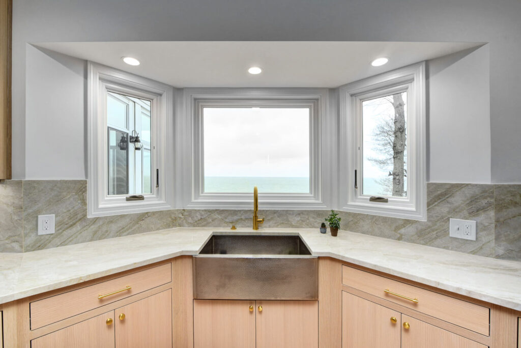 A kitchen featuring a sink and a window that offers a view of the water outside.
