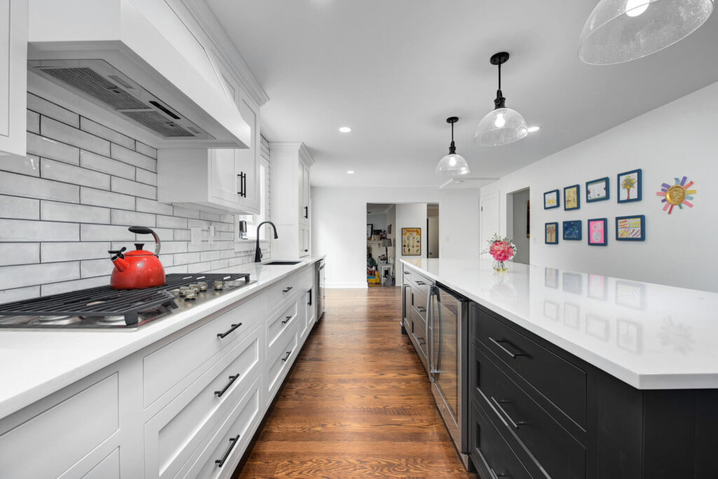 A modern kitchen featuring white cabinets and a sleek stove top, showcasing a clean and bright cooking space.