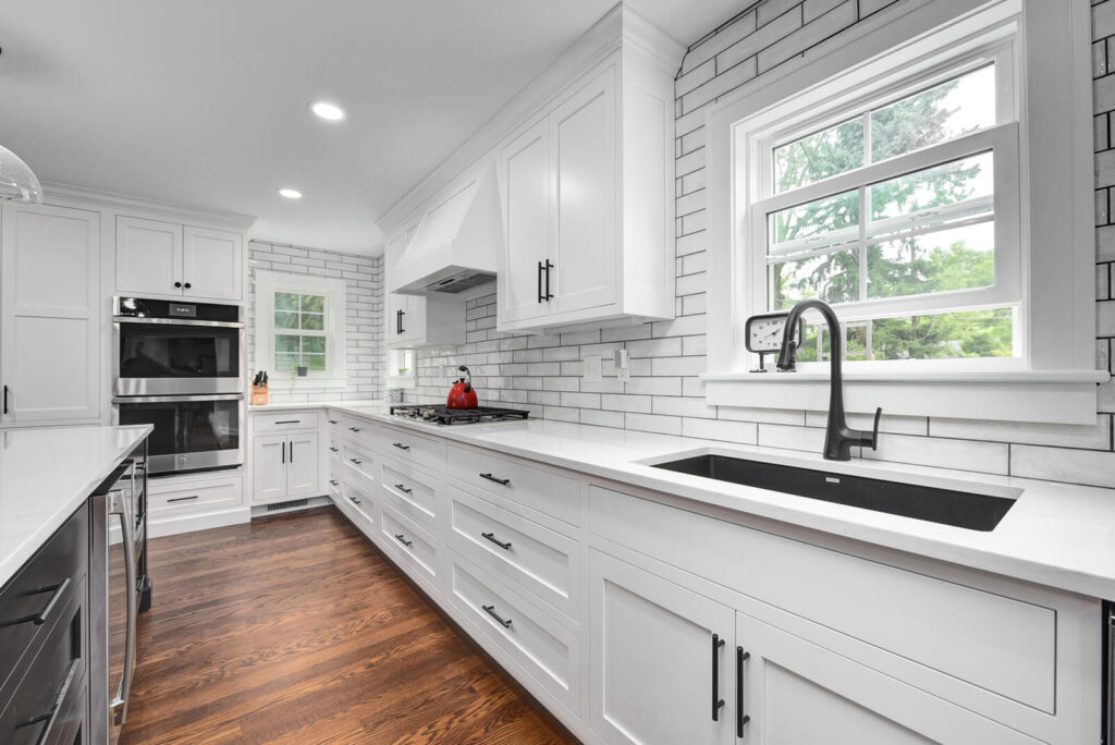A modern kitchen featuring sleek white cabinets paired with stylish black appliances, creating a contemporary aesthetic.