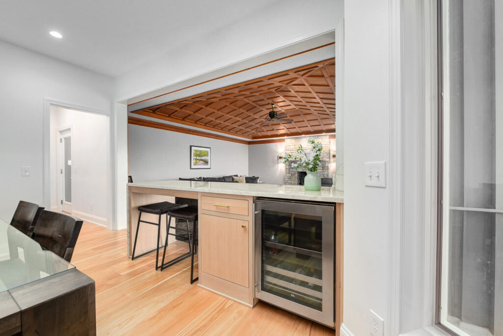 A modern kitchen featuring a stylish bar area alongside a spacious dining table for gatherings and meals.