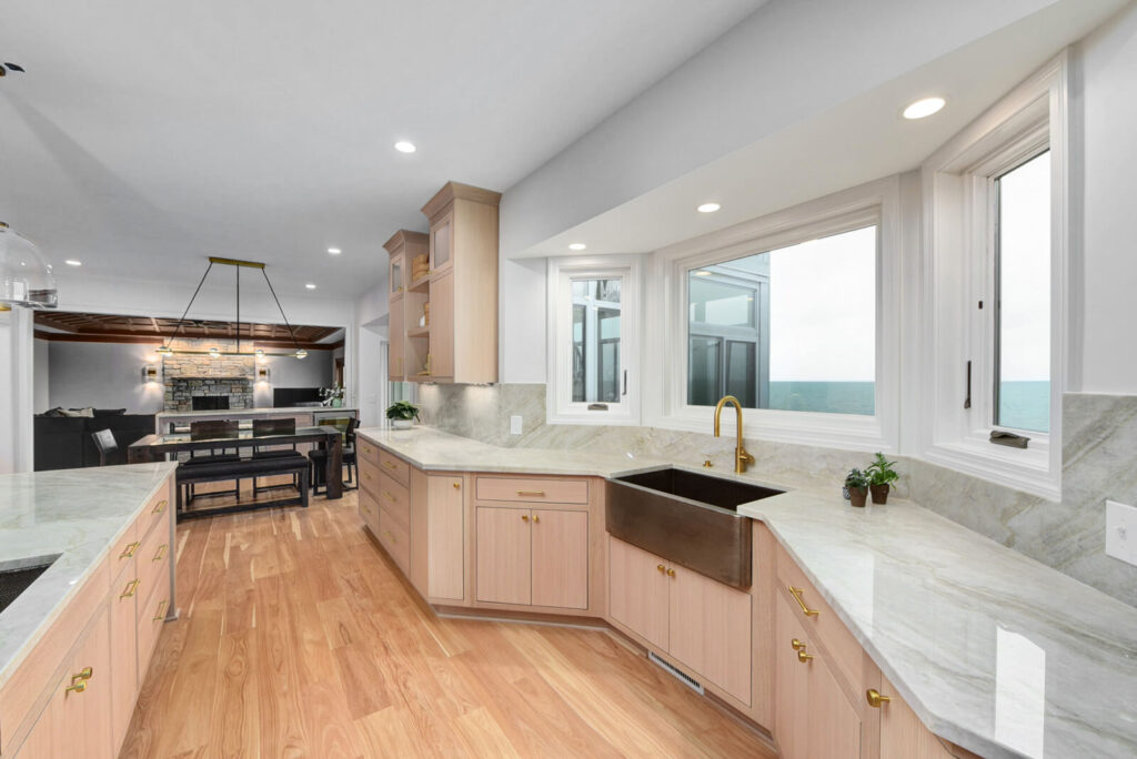 A modern kitchen featuring a sleek marble countertop and elegant wooden flooring.