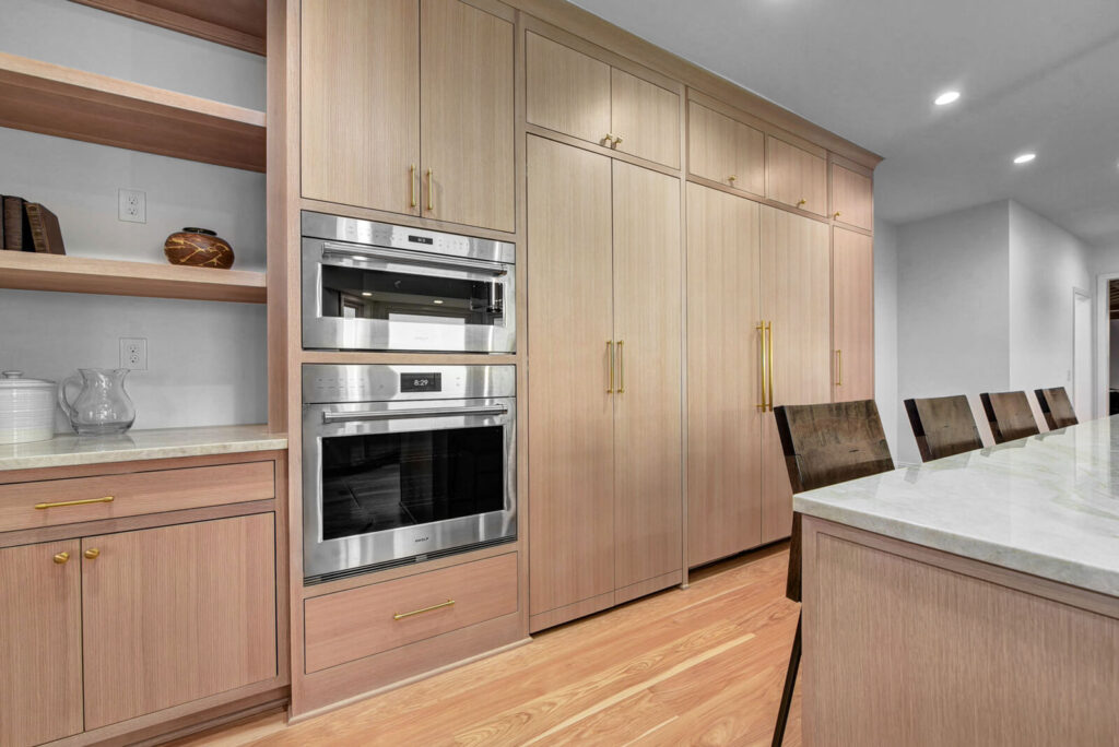 A modern kitchen featuring wooden cabinets and sleek stainless steel appliances, creating a warm and contemporary atmosphere.